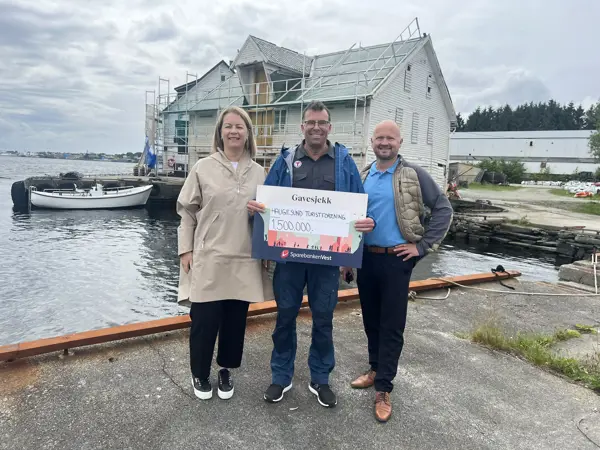 Banksjef Nina Hopsdal og regiondirektør Nils Mikal Emberland i Sparebanken Vest, sammen med styreleder i Haugesund Turistforening Rolf Børseth, som holder gavesjekken på 1,5 millioner kroner.