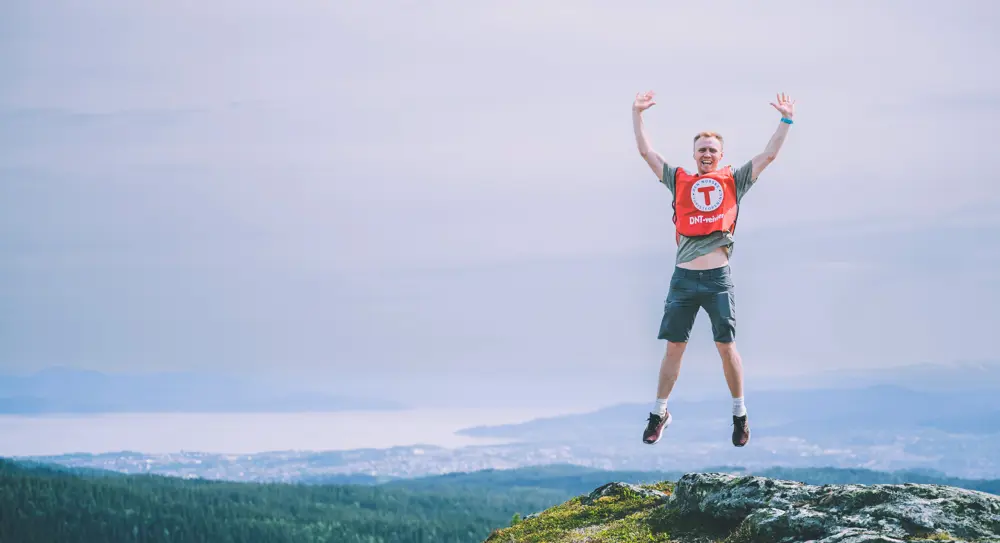 Mann hopper på fjell