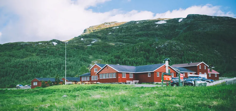 Den røde Aurlandsalen turisthytte står i stor kontrast med de frodige grønnfargene som omkranser bygget. 
