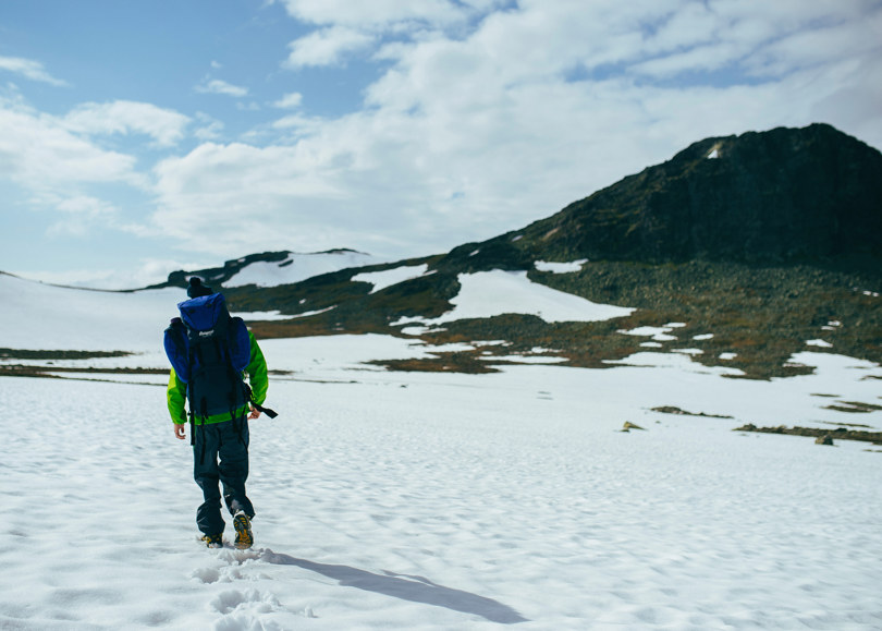 Turgåer over snødekt sommerlandskap