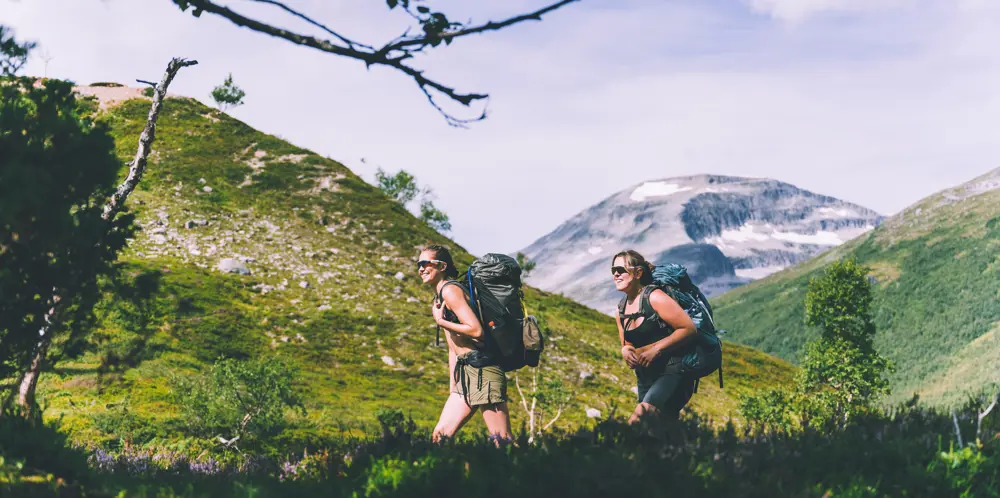 To damer med sekk på fjelltur