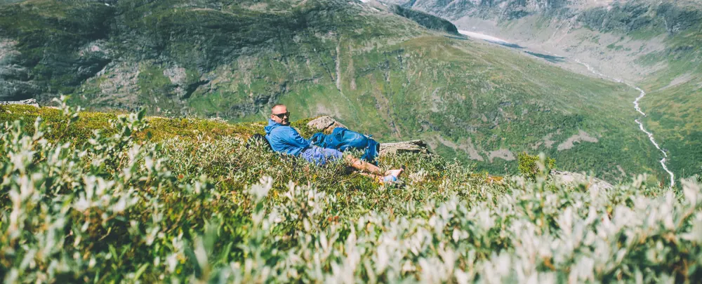 Mann sitter i lyngen i Jotunheimen