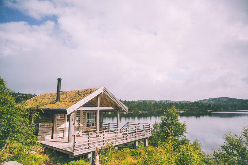 Hytte ved tjern i fjellet.