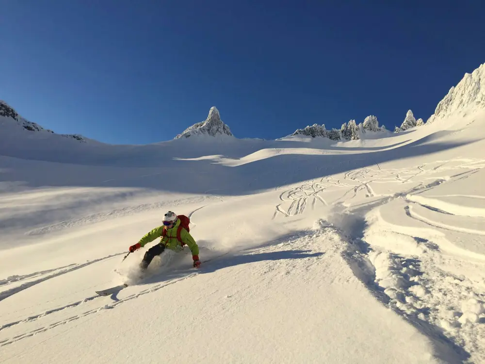 Telemarksving i perfekt pudder med den ber¯mte Fingeren pÂ Sunnm¯re i bakgrunnen.