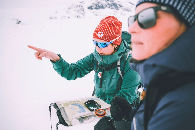 To personer ser på kart i vinterfjellet.