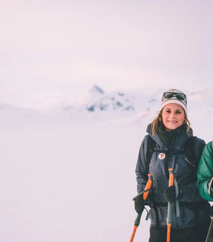 To smilende damer på ski på vinterfjellet. 