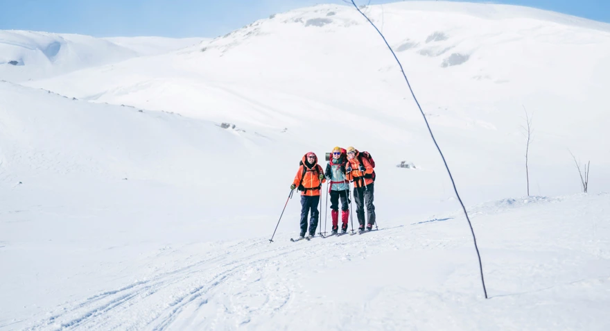 Tre personer med fjellski som går langs en kvistetløype