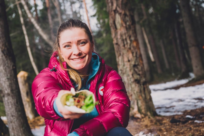 Kvinne holder tortillalefse med fyll foran seg.