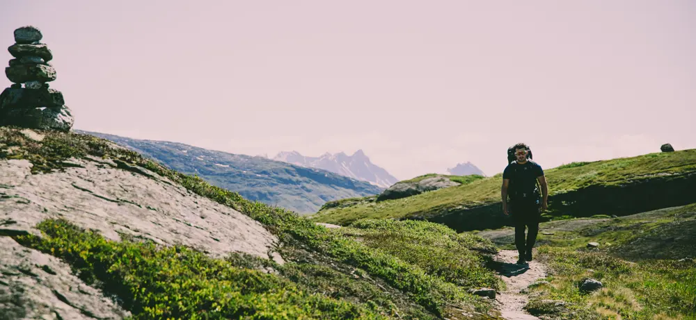 Mann som går tur på en sti i fjellet