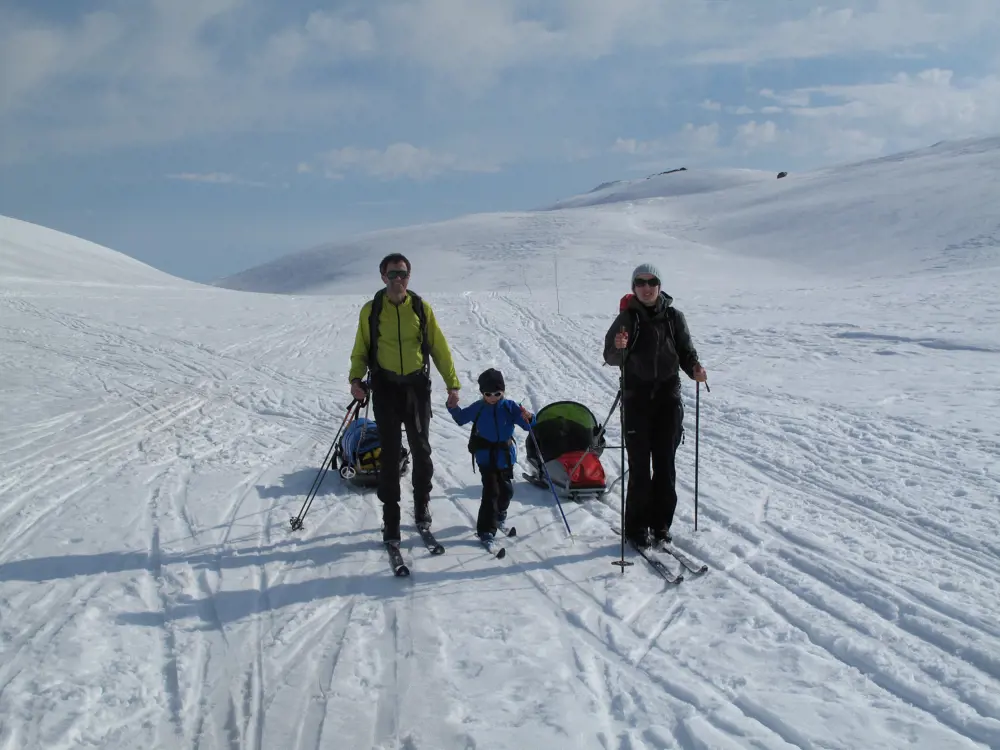 familie på ski, en med pulk.