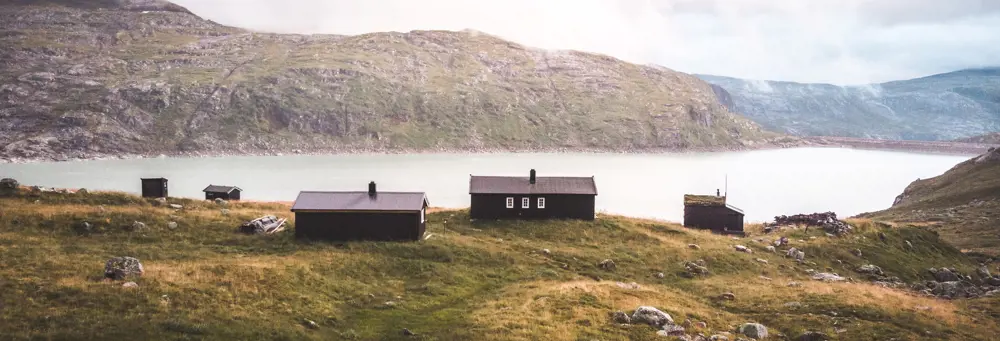 Fire hytter som ligger ved en innsjø