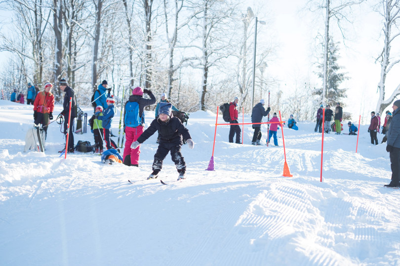 Barn står på ski i skileik.