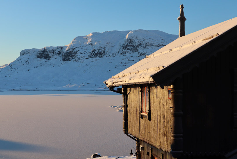 Snøen har lagt seg på vannet, fjellene og taket utenfor haukeliseter 