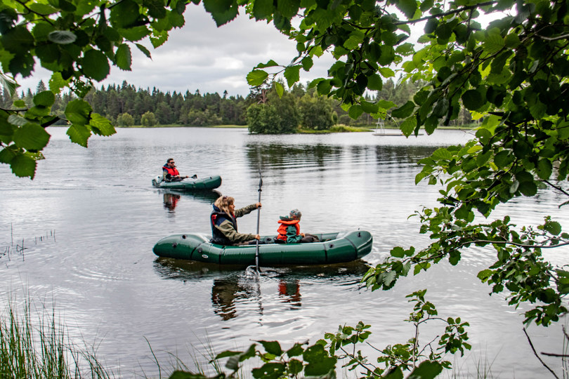 Tre personer fordelt på to packrafter på en innsjø