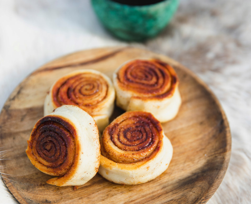 fire kanelsnurrer på en tallerken.