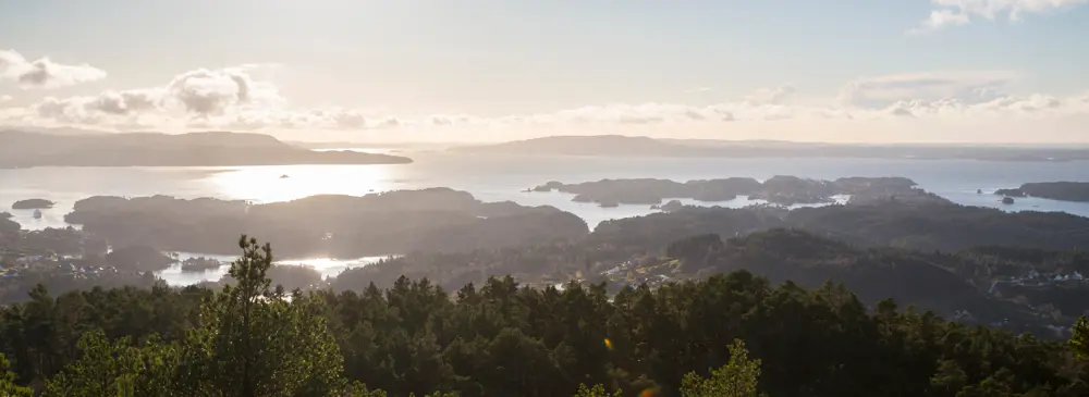 Utsikt over øyrike i Bjørnafjorden med sol, skyer og sjø.