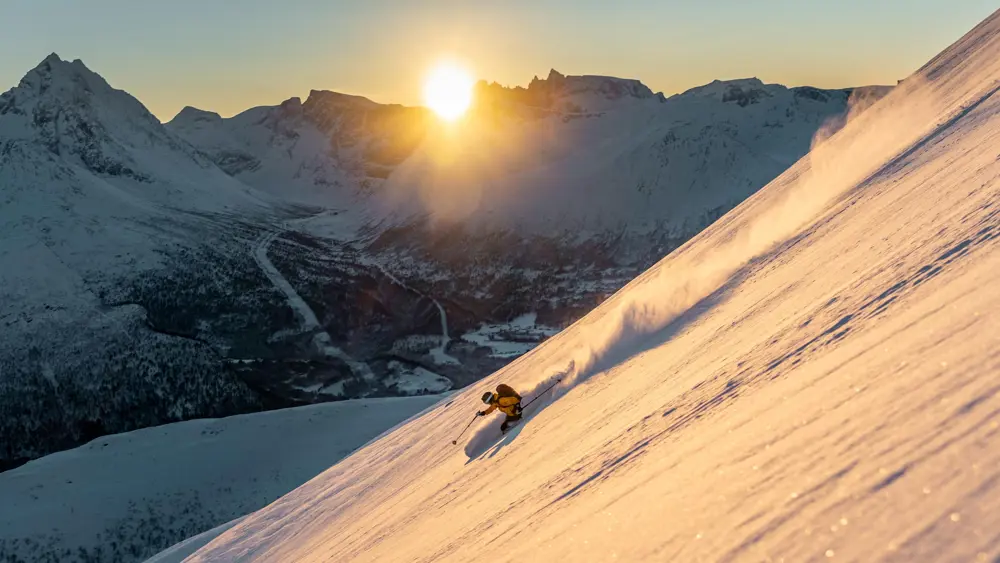 I Isfjorden pÂ vei ned fra Kyrkjetaket. Kristin Helland-Hansen setter en deilig sving i ur¯rt sn¯ med Trolveggen og Vengetind i bakgrunnen.