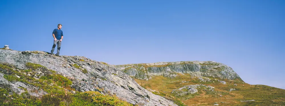 Bilde tatt med drone av en hytte i solskinn