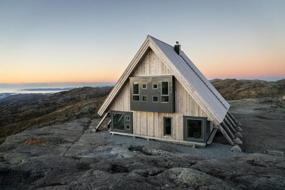 Hytte med skråtak på fjellplatå.