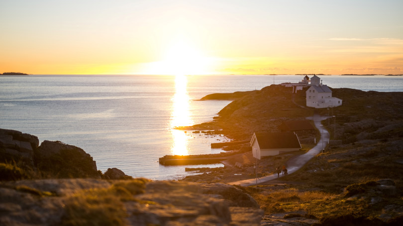 Solnedgang på Fjøløy. Fyrtårn i det fjerne.