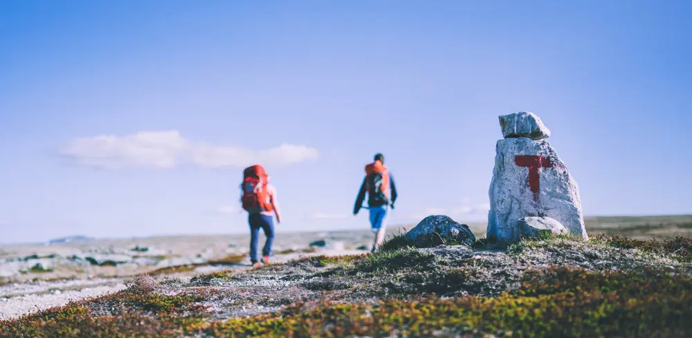 To turgåere i fjellet, stein med rød T 