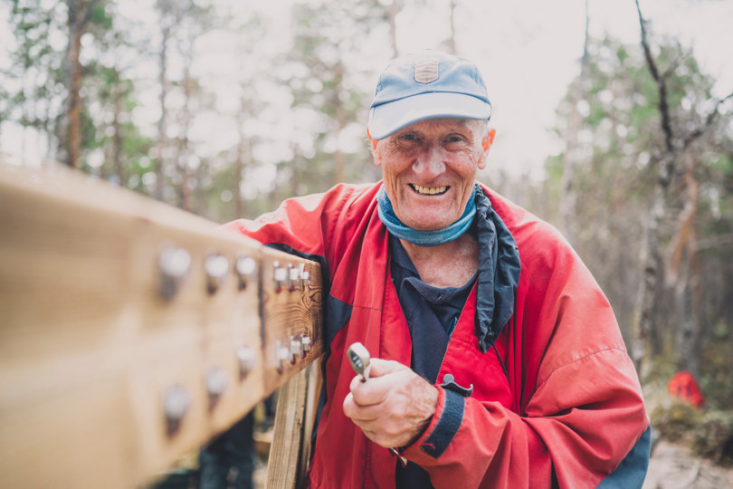 Smilende mann bygger bygger bro. 