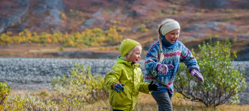 To glade barn løper ute i naturen