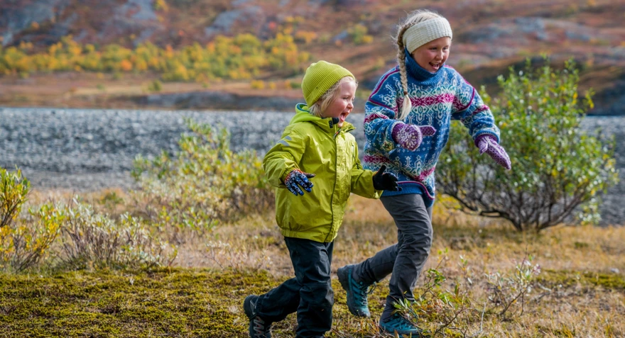 To glade barn løper ute i naturen