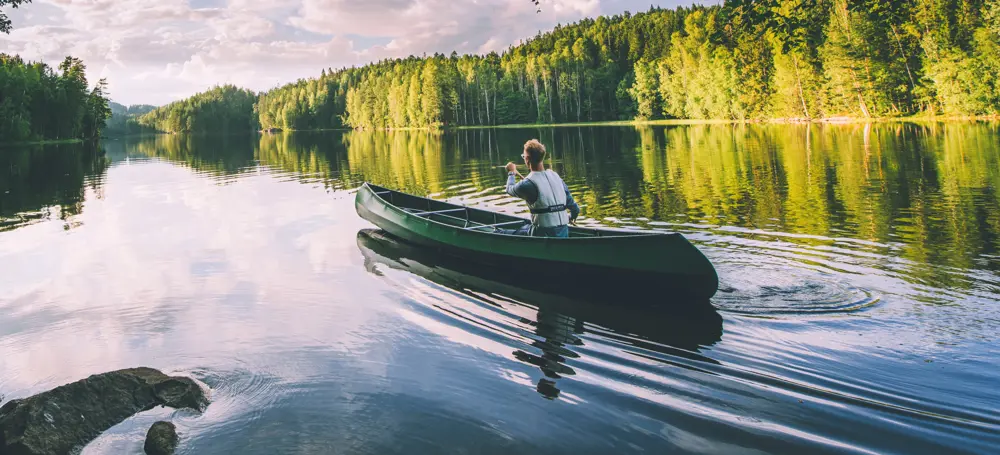 Kanopadler i skogsvann