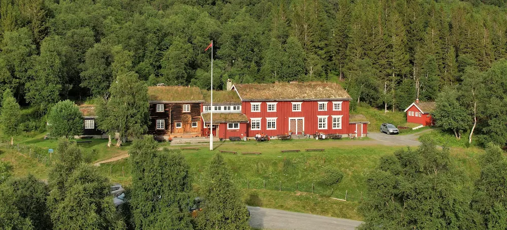 Rød turisthytte i skogbrynet