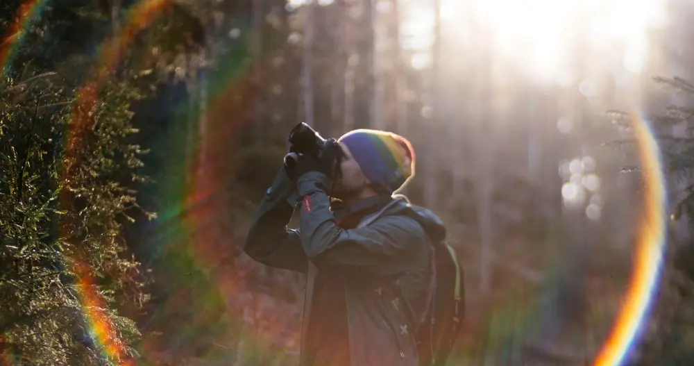 mann med kamera i skogen