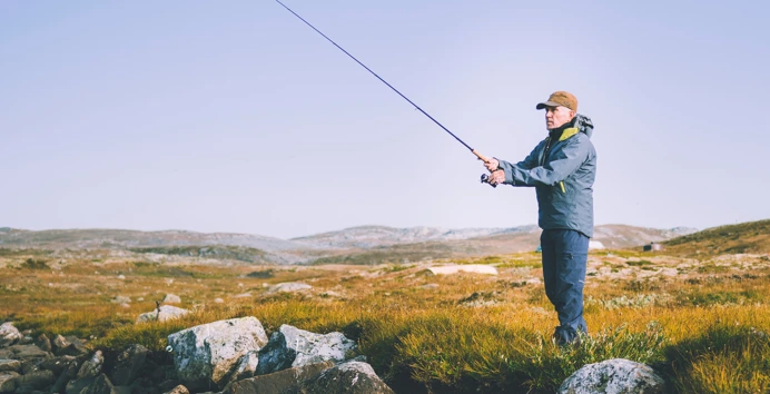 Reportasjetur over Hardangervidda i forbindele med jubileumsbok. Turgåer fisker ved vannet nedenfor Litlos turisthytte.