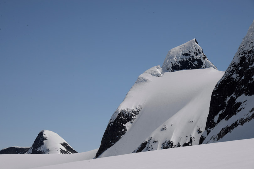 Høy og spiss fjelltopp dekket med snø.