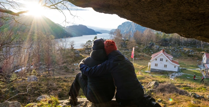 To personer som holder rundt hverandre under en fjellhylle.
