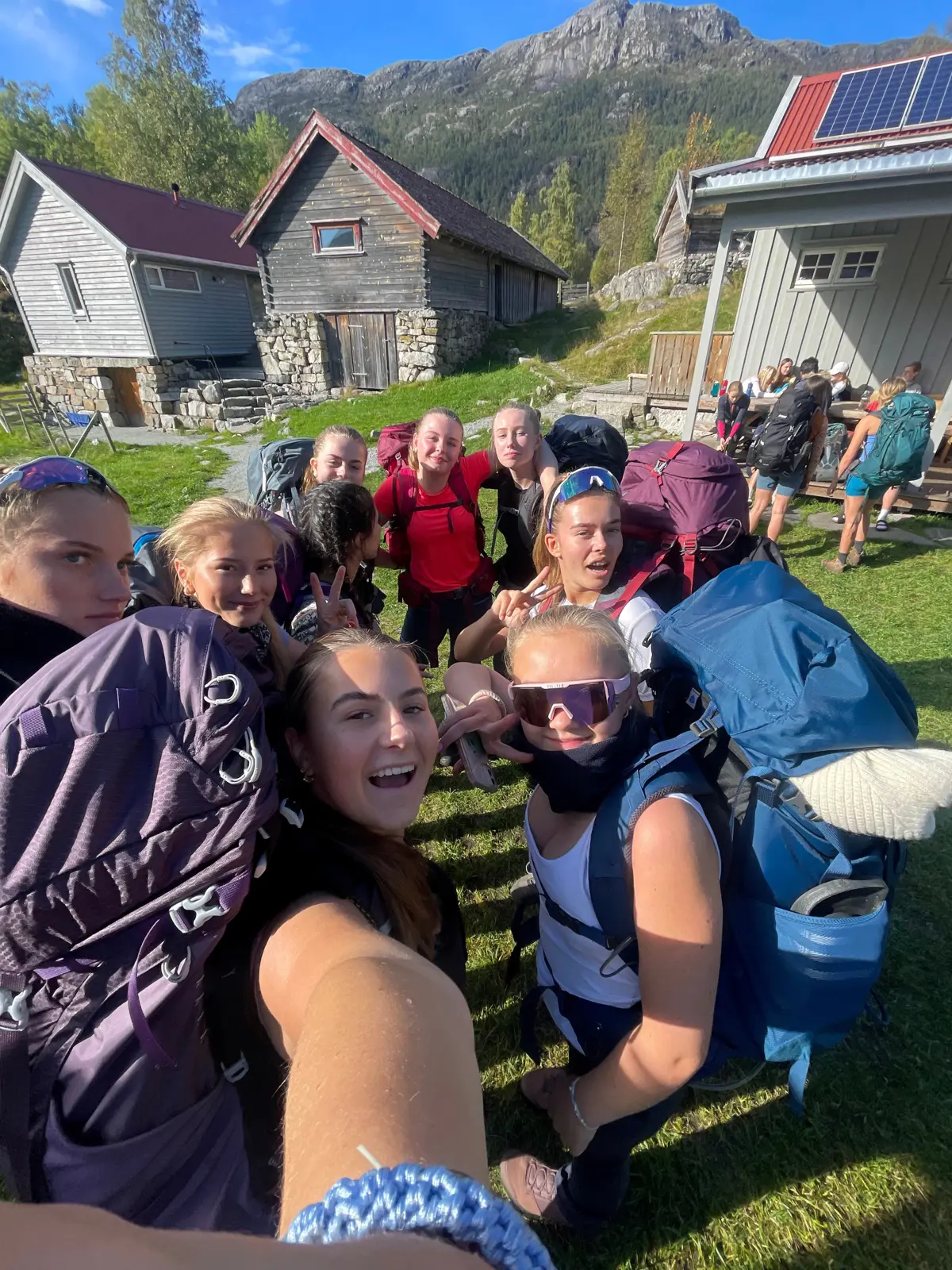 Ungdommer tar selfie av seg selv utenfor en hytte.