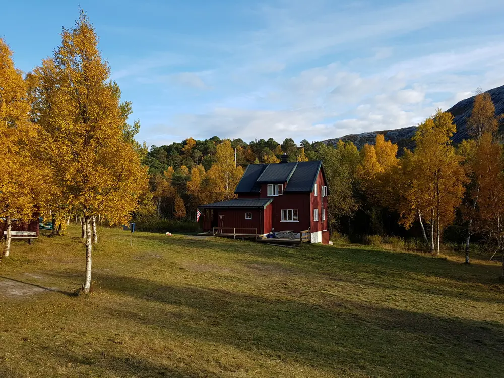 Gjælentunet - hovedhuset med flotte høstfarger i skogen rundt