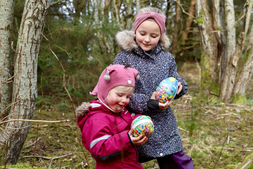 To jenter med påskeegg i skogen