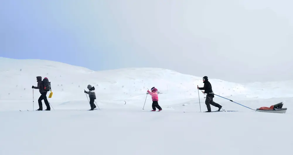 Familie på skitur i finvær