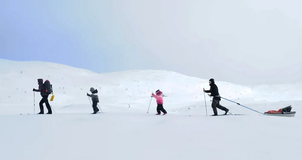 Familie på skitur i finvær
