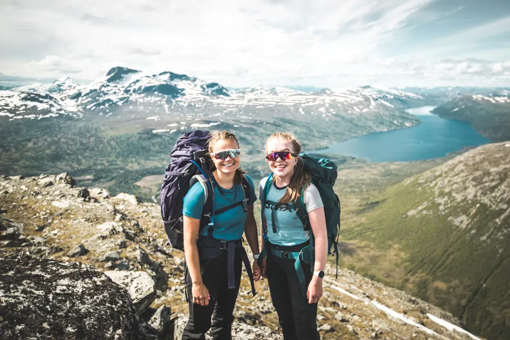 To jenter med tursekker i fjellet.