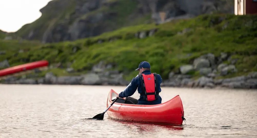 En mann som padler i en rød kano på Stranddalsvatnet.