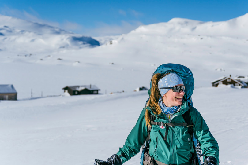 Dama på ski i høyfjellet - med stor sekk