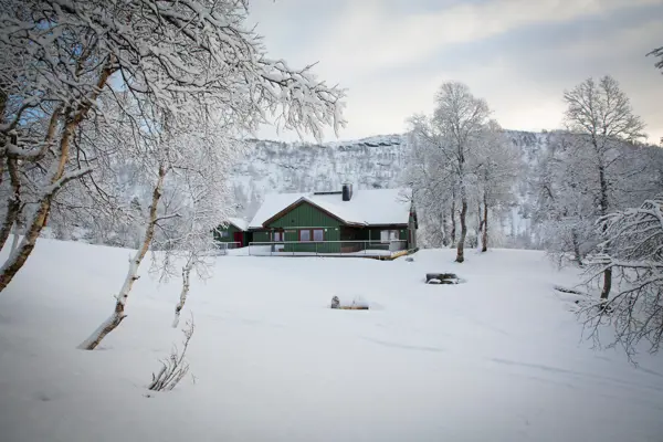 Hytte i snødekt landskap.
