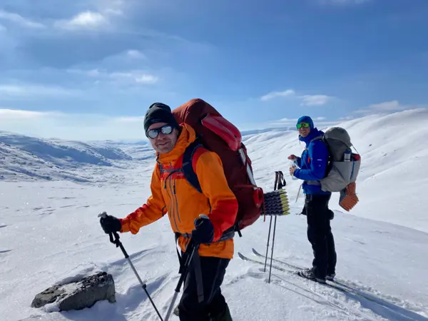 To personer på ski i vinterlandskap.