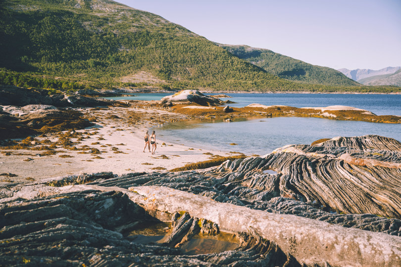 To damer går på strand, svaberg