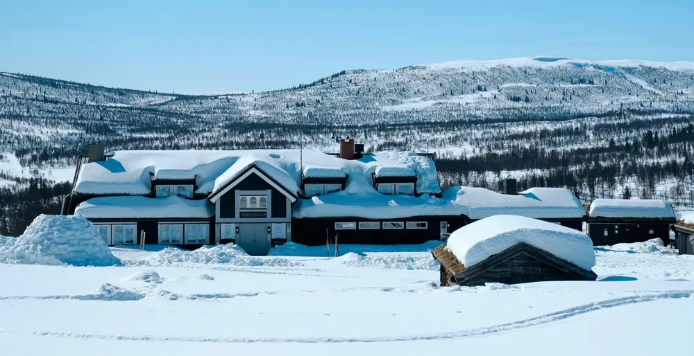 Bilde av hytte i vakkert landskap med snø