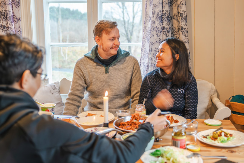 et par som sitter ved et bord og spiser mat