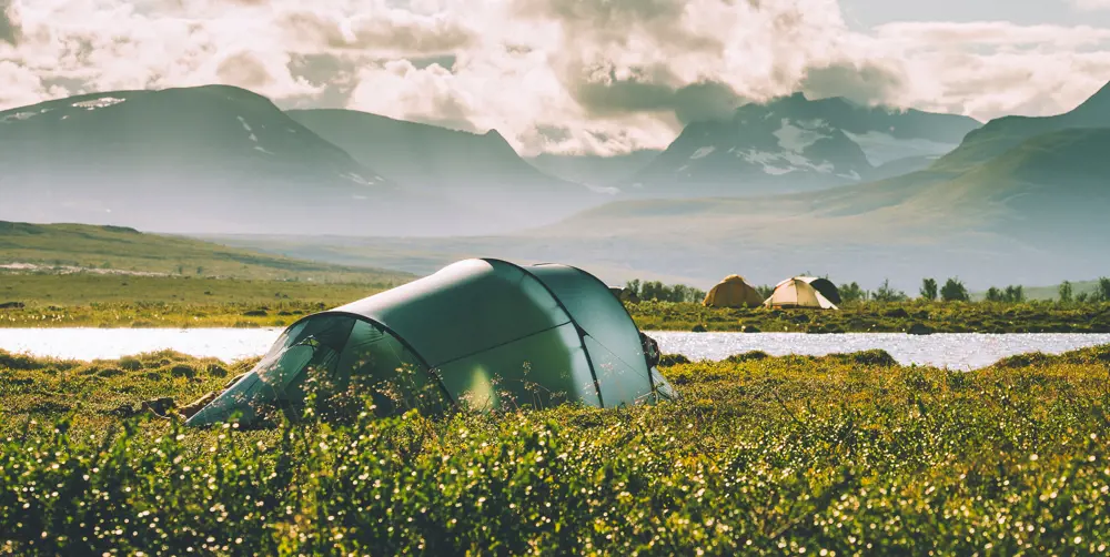 Et grønt telt som er satt opp i lyng