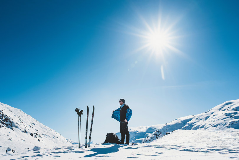 Mann som soler seg i vinterfjellet