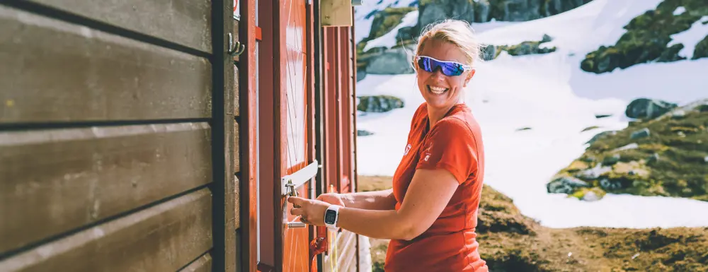 Woman unlocking a DNT-cabin with the DNT-key